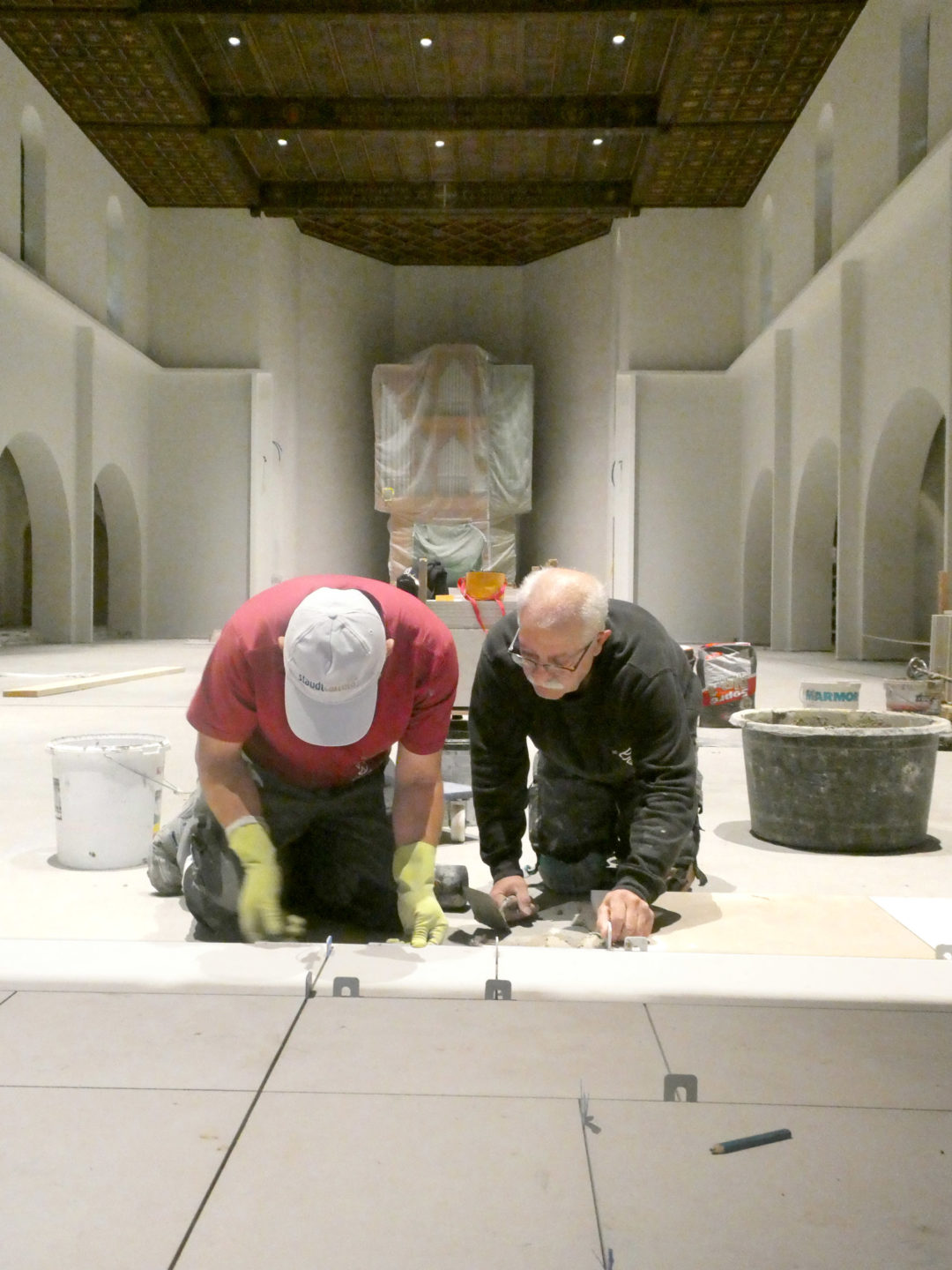 Zwei Bodenleger an der Arbeit in der Kirche Franz Xaver in Münchenstein (BL). (Foto: ufw)